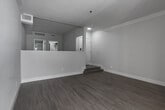 Located at 1959 Rochester Ave in the Westwood neighborhood of Los Angeles, this single-floor unit presents a thoughtfully updated interior with a clean, contemporary design throughout. The open living area serves as the centerpiece of the space, finished with light wood flooring that extends seamlessly across the unit. A classic fireplace with a white surround anchors one wall, while a large floor-to-ceiling window floods the room with natural light and provides views of lush greenery outside. A ceiling fan adds a functional accent overhead, enhancing the airy, comfortable atmosphere.

The galley-style kitchen features white cabinetry with matte black hardware, dark countertops, a black undermount sink, and a full suite of black stainless appliances including a gas range, refrigerator, and microwave. Track lighting illuminates the workspace efficiently. An entry area with a short step transition provides a welcoming introduction to the unit, with access to closet space nearby.

The bathroom has been fully renovated with a modern aesthetic, showcasing large-format gray tile, a glass-enclosed walk-in shower with a rainfall showerhead, a white vanity with dark countertops, a backlit LED mirror, and matte black fixtures throughout. The result is a polished, spa-like finish that complements the overall contemporary feel of the space.