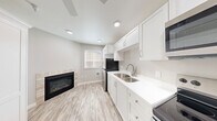 This 250 square foot studio apartment in Bend, Oregon, exemplifies efficient living with a thoughtful, modern design. The open-concept layout maximizes the use of space, creating a seamless flow between living areas. The kitchen boasts white cabinetry, stainless steel appliances, and a built-in microwave, offering functionality in a compact footprint. Light-toned wood-look flooring extends throughout, unifying the space and enhancing the sense of openness.

The bathroom features a clean, contemporary design with a white vanity, ample storage, and a mirror flanked by modern lighting. In-unit laundry facilities, including a stacked washer and dryer, add convenience to this small living space. A standout feature is the cozy fireplace with a tiled surround, providing warmth and ambiance. Large windows allow natural light to flood the space, while recessed lighting and a ceiling fan ensure comfort and illumination.

Despite its small size, the apartment doesn't compromise on amenities, offering a full kitchen, separate bathroom, and dedicated laundry area. The neutral color palette and modern fixtures create a fresh, inviting atmosphere in this efficiently designed urban dwelling.