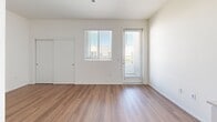 Located at 4212 Genesee Ave in San Diego, CA, this efficiently designed single-floor unit offers a clean, modern aesthetic throughout. The main living area features warm wood-look laminate flooring, crisp white walls, and a sizable window with blinds alongside a glazed entry door that allows natural light to fill the space. A sliding closet door provides convenient built-in storage within the living area.

The kitchen is thoughtfully laid out along a single wall, maximizing the available space. White shaker-style cabinetry with brushed nickel hardware extends both above and below the countertops, offering ample storage. A double-basin stainless steel sink, electric range with oven, and a full-size refrigerator complete the functional cooking space, all finished with neutral countertops that complement the overall palette.

The bathroom is outfitted with a full tub-shower combination featuring a curved curtain rod, a tiled surround, and multiple stainless steel grab bars, reflecting a thoughtful, accessibility-conscious design. Warm wood-look flooring continues into the bathroom, maintaining a cohesive aesthetic.

Overall, the unit presents a bright, clean, and functional living environment with consistent modern finishes, making it a practical and comfortable space in the Clairemont neighborhood of San Diego.