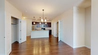 This single-floor residence offers a well-designed open-concept layout that seamlessly connects the kitchen, dining, and living areas. The kitchen is a standout feature, equipped with rich dark-espresso cabinetry, granite countertops, a tile backsplash, and a full suite of stainless steel appliances including a refrigerator, range, and built-in microwave. A large central island with a granite surface and an integrated sink serves as both a functional workspace and a natural gathering point, illuminated by a trio of pendant lights overhead.

The living and dining areas are finished with warm hardwood-style flooring, and a built-in shelving unit adds practical storage. Bedrooms are carpeted for comfort, each featuring ceiling fans, natural light from multiple windows, and generous walk-in closets with built-in shelving and hanging rods. The bathrooms are appointed with dark-wood vanities, white countertops, and tile flooring. One bathroom provides direct access to a walk-in closet. Throughout the unit, neutral wall tones and clean white trim create a cohesive, move-in-ready aesthetic.