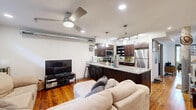 Located at 1111 Hawthorne Ln in Charlotte, NC, this two-floor loft-style space blends industrial character with comfortable living across a generous layout. The main floor accommodates the primary living areas, including a combined kitchen and living room, two bathrooms, and a dedicated office, while the upper level hosts the private bedroom retreat.

The kitchen is a standout feature, offering rich dark-wood cabinetry, granite countertops with a breakfast bar, stainless steel appliances, and warm hardwood flooring — all anchored by a rustic structural column that nods to the building's industrial heritage. The adjoining living room provides a relaxed atmosphere with recessed lighting, a ceiling fan, clerestory windows that draw in natural light, and rich hardwood floors throughout.

The office space makes a striking impression with soaring ceilings, dramatic floor-to-ceiling industrial steel-frame windows, and an exposed brick wall that floods the room with natural light and urban character.

The bedroom features a wood-beam ceiling with a ceiling fan, hardwood floors, and clerestory windows. Exposed structural elements continue the loft aesthetic. Both bathrooms are clean and functional, with tile flooring and classic fixtures. The upper-floor bathroom is tucked beneath the sloped roofline, adding a cozy, architectural touch to the space.