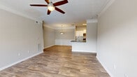 This single-story, 2-bedroom, 2-bathroom residence offers a thoughtfully designed layout that balances comfort and functionality. The open-concept living and dining area features warm hardwood-style flooring, crown molding, and a ceiling fan, creating an inviting atmosphere. The dining area is distinguished by elegant wainscoting panels and a pendant light fixture, adding a refined architectural touch. The kitchen is well-equipped with stainless steel appliances, including a refrigerator, microwave, and dishwasher, complemented by white shaker-style cabinetry, dark countertops, and a classic subway tile backsplash. A pass-through counter connects the kitchen to the living area, enhancing the open feel of the space. Both bedrooms are carpeted and receive natural light through large windows fitted with blinds. The generously sized primary bedroom includes a walk-in closet with wire shelving for organized storage. Two full bathrooms serve the home, each featuring a tub/shower combination. A dedicated laundry area accommodates a full-size washer and dryer. The entrance opens into the bright, airy living room, completing a practical and comfortable floor plan throughout.