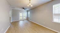 Located at 2109 Oglethorpe Circle in Pooler, Georgia, this two-story, three-bedroom, four-bathroom home offers a well-organized layout spread across two floors. The main level serves as the heart of the home, featuring a spacious living room adorned with light hardwood-style flooring, a ceiling fan, an elegant chandelier, and French doors that invite natural light and outdoor views. An adjoining dining or flex area carries the same warm flooring and is illuminated by a gold chandelier, creating a cohesive and welcoming atmosphere throughout.

The kitchen is designed for functionality, featuring a U-shaped layout with rich cherry wood cabinetry, light countertops, a double-basin sink beneath a window, and stainless steel appliances including a refrigerator and range. Tile flooring grounds the space and complements the warm cabinetry tones.

Upstairs, the primary bedroom features vaulted ceilings, a ceiling fan, plush carpet, and a generous closet. The additional bedrooms are carpeted, well-lit by multiple windows with natural views, and offer ample closet storage. The bathrooms are finished with tile flooring, and one features a distinctive octagonal window above a soaking tub. The home's hallways are clean and functional, connecting the spaces efficiently across both levels.