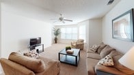This single-floor residence in Camden, South Carolina offers a well-organized layout designed for comfortable everyday living. The living room is generously sized, featuring plush carpeting, a ceiling fan with light fixture, and multiple windows that allow abundant natural light to fill the space. The room comfortably accommodates a full seating arrangement, making it ideal for both relaxing and entertaining.

The kitchen is equipped with ample wood-toned cabinetry, a coil-burner electric range, a stainless steel sink, and a pass-through countertop that connects to the adjacent dining area. The dining space features a pendant light fixture overhead and provides a comfortable setting for everyday meals.

The primary bedroom is a well-proportioned retreat with soft carpeting, a ceiling fan, natural light from a window with blinds, and a direct en-suite bathroom connection. The en-suite bathroom includes a tub-shower combination with a decorative shower curtain and tile flooring. A second bedroom provides additional versatility, also featuring carpet flooring and a ceiling fan. A second full bathroom with tiled floors serves the remainder of the unit.

Throughout the residence, neutral tones, textured ceilings, and consistent carpeting in the main living areas create a cohesive and welcoming ambiance.