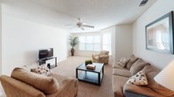 This single-floor residence in Camden, South Carolina offers a well-organized layout designed for comfortable everyday living. The living room is generously sized, featuring plush carpeting, a ceiling fan with light fixture, and multiple windows that allow abundant natural light to fill the space. The room comfortably accommodates a full seating arrangement, making it ideal for both relaxing and entertaining.

The kitchen is equipped with ample wood-toned cabinetry, a coil-burner electric range, a stainless steel sink, and a pass-through countertop that connects to the adjacent dining area. The dining space features a pendant light fixture overhead and provides a comfortable setting for everyday meals.

The primary bedroom is a well-proportioned retreat with soft carpeting, a ceiling fan, natural light from a window with blinds, and a direct en-suite bathroom connection. The en-suite bathroom includes a tub-shower combination with a decorative shower curtain and tile flooring. A second bedroom provides additional versatility, also featuring carpet flooring and a ceiling fan. A second full bathroom with tiled floors serves the remainder of the unit.

Throughout the residence, neutral tones, textured ceilings, and consistent carpeting in the main living areas create a cohesive and welcoming ambiance.