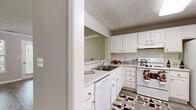 Located in Sandy Springs, GA, this single-floor 2-bedroom, 1-bathroom residence offers a practical and comfortable layout across a generously sized floor plan. The combined kitchen and living room serves as the heart of the home, with the living area showcasing wood-look laminate flooring, crown molding, a textured ceiling, and large windows that invite abundant natural light and views of the surrounding greenery. The kitchen features white cabinetry with ample storage, white appliances including a range, dishwasher, and refrigerator, along with a double-basin sink and a pass-through window that enhances the open feel. The spacious primary bedroom is carpeted and benefits from natural light through a window, while the second bedroom offers similar comfort with soft carpeting and a textured ceiling. Both rooms are well-proportioned and versatile. Two closets provide strong storage capacity, each fitted with multi-tiered wire shelving systems and carpeted floors. The bathroom includes a wide vanity with white cabinetry, a large mirror, and a shower-tub combination. Throughout the residence, neutral tones and clean finishes create a cohesive, move-in-ready ambiance.