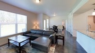 This single-floor residence offers a clean, modern aesthetic with a thoughtfully designed open-concept layout. The living area is anchored by polished concrete floors that extend throughout the home, creating a sleek and cohesive look. Natural light filters in through multiple windows fitted with blinds, brightening the connected living and dining spaces. The living room provides generous seating space, while the adjacent dining area features direct access to the outdoors through a glass door.

The kitchen is outfitted with stainless steel appliances, including a Whirlpool refrigerator with an ice maker, an electric range, and an over-the-range microwave. Gray shaker-style cabinetry pairs with granite-patterned countertops to deliver a contemporary and functional workspace.

The bedrooms are comfortably sized, each equipped with a ceiling fan and large windows that bring in outdoor views and natural light. One bedroom includes a walk-in closet with wire shelving for organized storage.

The bathrooms are finished with gray vanity cabinets, granite-style countertops, and well-lit mirrors. One bathroom features a tiled tub-shower combination with a curved curtain rod. Throughout the home, the neutral color palette and consistent finishes create a cohesive, move-in-ready environment.