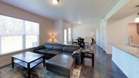 This single-floor residence offers a clean, modern aesthetic with a thoughtfully designed open-concept layout. The living area is anchored by polished concrete floors that extend throughout the home, creating a sleek and cohesive look. Natural light filters in through multiple windows fitted with blinds, brightening the connected living and dining spaces. The living room provides generous seating space, while the adjacent dining area features direct access to the outdoors through a glass door.

The kitchen is outfitted with stainless steel appliances, including a Whirlpool refrigerator with an ice maker, an electric range, and an over-the-range microwave. Gray shaker-style cabinetry pairs with granite-patterned countertops to deliver a contemporary and functional workspace.

The bedrooms are comfortably sized, each equipped with a ceiling fan and large windows that bring in outdoor views and natural light. One bedroom includes a walk-in closet with wire shelving for organized storage.

The bathrooms are finished with gray vanity cabinets, granite-style countertops, and well-lit mirrors. One bathroom features a tiled tub-shower combination with a curved curtain rod. Throughout the home, the neutral color palette and consistent finishes create a cohesive, move-in-ready environment.