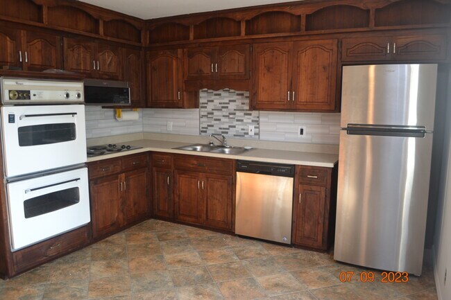 Eat-in Kitchen with custom hardwood cabinets, new counter and backsplash. - 15314 Fuller Ave