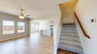 Located at 1421 Twin Forks Dr in Saginaw, TX, this two-story home offers a well-designed layout spread across two floors. The main level opens into a bright, open-concept living area with wood-look tile flooring, neutral tones, and abundant natural light streaming through multiple windows. A ceiling fan anchors the living space, which flows seamlessly into the kitchen. The kitchen is a standout feature, boasting gray shaker-style cabinetry, quartz countertops, a large center island with a sink, subway tile backsplash, and stainless steel appliances including a gas range, microwave, and refrigerator. A dedicated laundry room with washer and dryer hookups adds everyday convenience on the main level. Carpeted stairs lead to the upper floor, where three bedrooms are situated. The generously sized primary bedroom includes a walk-in closet with built-in shelving and natural light. Secondary bedrooms are carpeted, each featuring a ceiling fan, closet, and windows. The bathrooms are well-appointed, with one showcasing a soaking tub framed by large-format marble-look tile. The fenced backyard provides a private outdoor retreat. With four bathrooms serving three bedrooms and a clean, modern aesthetic throughout, this home offers practical comfort and style.