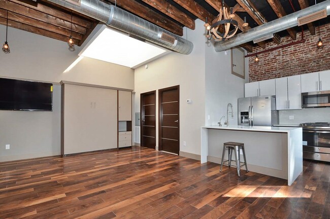 Open concept soaring 16 foot ceilings, exposed wood beams, exposed brick walls, oversized skylights, custom European kitchens, stainless steel appliances, and quartz waterfall countertops. - 621 14th St