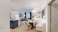 Located at 1250 Marden Rd in Apopka, Florida, this single-floor, 2-bedroom, 2-bathroom residence offers a thoughtfully designed open-concept layout that seamlessly connects the kitchen, dining, and living areas. Light wood-style flooring flows throughout the main living spaces, complemented by an abundance of natural light from large windows dressed in elegant navy drapes.

The kitchen is a standout feature, boasting two-tone cabinetry — navy lower cabinets paired with crisp white uppers — set against white quartz countertops and stainless steel appliances, including a range and over-the-range microwave. A kitchen island with pendant lighting provides additional prep and dining space.

The living room is bright and inviting, with a ceiling fan, large windows, and direct access to an outdoor area. The dining nook, illuminated by a statement pendant light, adds a charming focal point to the open layout.

Both bedrooms are carpeted and well-sized, each with ceiling fans and dedicated closets. The primary bedroom includes a spacious walk-in closet with built-in shelving and organizational systems. The bathrooms are finished with white shaker cabinetry, dual vanities with backlit mirrors, and glass-enclosed shower and tub combinations.

A dedicated laundry room with a full-size washer and dryer rounds out this functional and stylish residence.