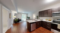 Located at 700 Citation Ln in Cherry Hill, NJ, this well-appointed single-floor residence offers a thoughtfully designed open-concept layout that seamlessly connects the living, dining, and kitchen areas. Rich hardwood flooring flows throughout the main living spaces, complementing the neutral, light-toned walls that create a bright and welcoming ambiance. The kitchen is a standout feature, boasting dark espresso cabinetry, a full suite of stainless steel appliances including a refrigerator, range, microwave, and dishwasher, and a peninsula with seating that bridges the cooking and dining areas. The living room is generously sized and benefits from a large sliding glass door that invites abundant natural light and provides outdoor access. Two well-proportioned bedrooms each feature plush carpeting and large windows overlooking greenery. The primary bathroom impresses with large-format marble-look tile flooring, a dual-sink vanity with dark cabinetry, and clean, modern finishes. A dedicated in-unit laundry room with a full-size washer and dryer adds practical convenience. This residence combines contemporary finishes with a functional floor plan, making it an ideal home in Cherry Hill.