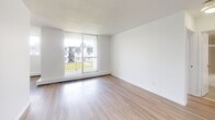 Located at Traynor Ave in Kitchener, Ontario, this well-appointed 1-bedroom, 1-bathroom unit offers a clean and modern living environment across a single floor. The living room is a bright, open space highlighted by large sliding glass doors that lead directly to a private balcony, allowing generous natural light to fill the room and offering views of the surrounding greenery. Light-toned hardwood-style flooring runs throughout the main living areas, contributing to a warm and cohesive aesthetic. The bedroom is a comfortable, well-sized room featuring a large window that brings in additional natural light, a baseboard heating unit, and a full-width built-in closet with sliding panel doors, providing ample storage. The bathroom is finished with neutral-toned floor and wall tiles, a full soaker tub and shower combo with a sleek chrome rail, a white vanity with under-sink storage, and a toilet — all neatly arranged in a compact, functional layout. Throughout the unit, crisp white walls and clean trim work create a fresh, move-in-ready atmosphere. The overall design is simple and practical, making it a well-suited space for comfortable everyday living in a residential Kitchener neighbourhood.