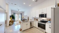Located at 1602 Belt Line Rd in Garland, TX, this thoughtfully designed one-bedroom, two-bathroom residence offers a modern and efficient single-floor layout. The open-concept kitchen anchors the living space with white shaker cabinetry extending to the ceiling, granite countertops, a peninsula with bar seating, and a full suite of stainless steel appliances. Polished concrete-style flooring flows seamlessly throughout, enhancing the clean, contemporary aesthetic. The living room is bright and welcoming, featuring large windows and a glass door that invite natural light and provide outdoor views. The spacious bedroom accommodates a full-sized bed comfortably, benefits from natural light through a large window, and connects directly to one of the two bathrooms, which features granite vanity counters and white cabinetry. A dedicated closet with built-in shelving and hanging rods offers organized storage. The second bathroom mirrors the same refined finishes and includes a tiled soaking tub and shower combination. High ceilings throughout contribute to an open, airy feel. The unit also includes a dedicated entryway, providing a clear sense of arrival and separation between the interior and exterior.