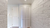 Located at 500 East Constitution Drive in Palatine, IL, this well-appointed single-floor unit offers 1 bedroom and 2 bathrooms within a thoughtfully designed layout. The exterior of the building features classic white brick construction surrounded by mature trees and maintained greenery.

The kitchen is a standout feature, showcasing sleek dark cabinetry, white subway tile backsplash, light quartz countertops, a central island, and a full suite of stainless steel appliances including a range, built-in microwave, dishwasher, and refrigerator. Light luxury vinyl plank flooring runs throughout the kitchen and living areas, providing a warm, modern aesthetic.

The combined kitchen and living room is bright and open, anchored by two sliding glass doors that bathe the space in natural light and provide views of the surrounding greenery. A ceiling fan adds comfort overhead.

The generously sized primary bedroom features soft carpeting, a ceiling fan, a double-door closet, and an additional walk-in closet, providing ample storage. Both bathrooms are finished with matching light vinyl flooring and include walk-in shower stalls with clean white surrounds. A hallway connects the rooms, completing this efficient and well-updated floor plan.