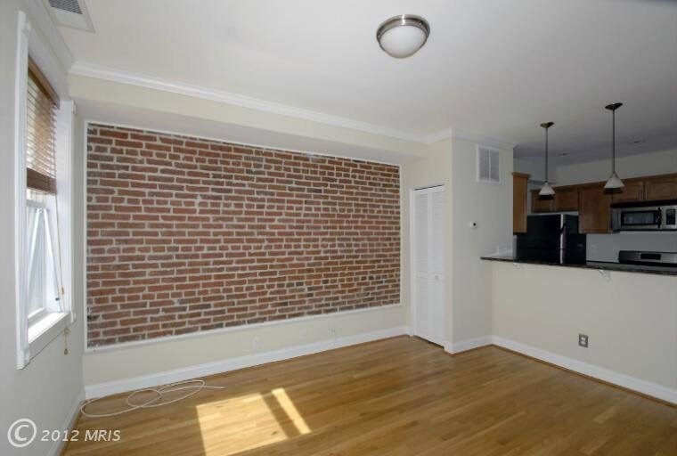 Sala de estar con paredes de ladrillo a la vista - 1350 E St NE