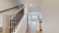 Located at 2257 Bayport Ave in Nashville, TN, this two-story home offers a well-designed layout spread across two floors. The main level features an open-concept kitchen and living area bathed in natural light from large windows. The kitchen is appointed with crisp white shaker cabinetry, granite countertops, stainless steel appliances including a range, microwave, dishwasher, and refrigerator, all complemented by light hardwood-style flooring. A glass-panel door in the living area provides additional natural light and outdoor access. A stylish staircase with a wood handrail and black iron balusters connects the floors. Upstairs, two carpeted bedrooms offer comfort and privacy, each featuring vaulted ceilings and windows with natural light. The generously sized primary bedroom includes its own closet. Three bathrooms throughout the home are finished with granite-topped white vanities and neutral tile flooring; one features a full tiled tub-shower surround. A dedicated laundry room with a window adds everyday convenience. Neutral, warm-toned walls and clean finishes throughout create a bright, move-in-ready atmosphere.