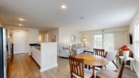 Located at 4170 Green Clover Drive in Hilliard, Ohio, this two-story home offers 2 bedrooms and 3 bathrooms across a well-designed layout. The main living level hosts the majority of the home's living space, while the ground floor provides an attached garage with an automatic opener and ample room for storage or parking.

The kitchen is a standout feature, showcasing white shaker cabinetry, dark granite countertops, stainless steel appliances including a full-size refrigerator and built-in microwave, and wood-look flooring. A breakfast bar peninsula connects the kitchen to the adjoining dining and living areas. The living room is bright and inviting, featuring a sliding glass door that opens to a balcony with outdoor views, wood-look flooring, and a neutral color palette throughout.

The primary bedroom is generously sized with plush carpeting, a ceiling fan, and warm, ambient lighting. The second bedroom, also carpeted, features a window with natural light and comfortable proportions. Two closets provide convenient storage. The three bathrooms are finished with dark granite vanities, white cabinetry, and tub-shower combinations. A hallway connects the upper-level rooms, with staircases linking both floors. The home's clean, contemporary finishes and functional layout make it a practical and comfortable residence.