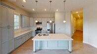 Located in Terrace Park, Rock Hill, South Carolina, this single-floor residence offers a thoughtfully designed layout with contemporary finishes and a cohesive neutral color palette throughout. The open-concept kitchen serves as a central feature of the home, showcasing gray shaker-style cabinetry, light quartz countertops, a classic subway tile backsplash, and stainless steel appliances including a range, built-in microwave, and French door refrigerator. A generously sized island with a built-in sink and pendant lighting above provides both additional workspace and a natural gathering point that flows seamlessly into the living area.

The living space features wood-look hard flooring, a ceiling fan, and multiple windows that invite natural light and neighborhood views. Bedrooms are finished with plush carpeting and ceiling fans, maintaining a comfortable, quiet atmosphere. A bright hallway with recessed lighting and clean white panel doors connects the rooms efficiently, with built-in shelving adding practical storage.

The bathroom is outfitted with large-format tile surrounding a soaking tub and shower combination, complemented by brushed gold hardware, a tiled floor, and a vanity with quartz countertops. Throughout the home, the clean lines, consistent finishes, and practical layout combine to create a comfortable and modern living environment.