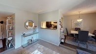 This single-floor apartment at The Summit Apartments offers a functional and thoughtfully designed layout across several connected living spaces. The living room serves as the heart of the home, featuring a sliding glass door that provides access to an outdoor balcony and fills the space with natural light. A textured ceiling and neutral gray walls create a calm, cohesive atmosphere throughout.

The galley-style kitchen is efficiently arranged with white cabinetry, dark granite-style countertops, black appliances, and wood-look flooring. A pass-through window connects the kitchen directly to the dining and living areas, enhancing the open feel of the common spaces.

The primary bedroom features plush carpeting, a ceiling fan with light fixture, and an en-suite bathroom. The bathroom includes a tub-shower combination, a vanity with a wide mirror, and accent lighting. A walk-in closet provides additional storage.

A second bedroom accommodates multiple beds and includes a ceiling fan, carpeted flooring, and ample wall space. Each bedroom maintains the unit's consistent neutral color palette. Throughout the apartment, textured ceilings, gray tones, and carpet in living areas provide a comfortable and unified residential environment.
