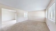 Located at 4113 NE Davidson Rd in Kansas City, MO, this tri-level home offers three bedrooms and three bathrooms distributed across three thoughtfully arranged floors. The main living area is generously sized, featuring warm neutral-toned carpet, large windows that invite natural light, and a distinctive brick fireplace surround anchoring the room alongside a sweeping staircase with a classic wrought-iron railing. The galley-style kitchen is well-equipped with white cabinetry, dark granite-look countertops, a tile backsplash, white appliances, and rich hardwood flooring that adds warmth to the space. Each of the three carpeted bedrooms offers a comfortable layout with access to natural light through windows fitted with blinds. The spacious primary bedroom includes dual closets for ample storage. Additional bedrooms are well-proportioned and feature their own closet space. The three bathrooms are consistently appointed with white vanity cabinets, dark countertops, tile backsplashes, and mirrors, with at least one bathroom featuring hardwood flooring and a walk-in shower. A dedicated utility room and hallway with staircase access complete the functional layout, making this home practical and well-organized throughout its three levels.