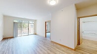 Located at 1818 N Commerce St in Milwaukee, Wisconsin, this two-bedroom, one-bathroom residence offers a well-organized, single-floor layout designed for comfortable everyday living. The main living area is bright and open, featuring light-toned hardwood flooring, neutral white walls, and a sliding glass door that leads to a private balcony overlooking greenery — allowing natural light to fill the space throughout the day.

The kitchen is thoughtfully equipped with warm wood cabinetry, stainless steel appliances including a refrigerator, electric range, and over-the-range microwave, complemented by a stone-finish peninsula countertop that provides additional prep and seating space.

Both bedrooms are carpeted for comfort and feature large windows that bring in natural light and neighborhood views. Each bedroom includes closet space, with at least one featuring a dedicated walk-in style closet with built-in shelving. The bedrooms connect conveniently to the rest of the unit via a central hallway.

The bathroom is clean and functional, featuring light hardwood-style flooring, a wood-trimmed vanity, and a full shower-tub combination. Warm wood trim throughout the unit ties the design together, creating a cohesive and inviting atmosphere suitable for a variety of lifestyles.