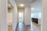 This thoughtfully designed 2-bedroom, 2-bathroom single-floor residence offers a comfortable and functional layout with modern finishes throughout. The open-concept kitchen and living area serves as the heart of the home, featuring rich dark wood cabinetry, stainless steel appliances including a refrigerator with ice maker, electric range, and built-in microwave, complemented by a large center island with a light countertop and pendant lighting overhead. Durable wood-style flooring runs through the main living areas, while large windows and vertical blinds allow for generous natural light.

The living room offers a bright, open feel with multiple windows providing outdoor views. Both bedrooms are carpeted and well-proportioned, with the primary bedroom offering ample space. The secondary bedroom includes a sliding closet door with built-in rod storage and ceiling fan. The two bathrooms are finished with dark wood vanities, light countertops, large mirrors, and a full tub-shower combination.

A dedicated laundry room houses a full-size side-by-side washer and dryer, adding everyday convenience. The overall aesthetic is clean and contemporary, with neutral wall tones, white trim, and consistent finishes that create a cohesive and inviting atmosphere throughout the space.