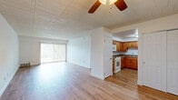Located at 140 Lavale Dr, Unit 507, in Monroeville, PA, this one-bedroom residence offers a well-organized single-floor layout with a living room, kitchen, bedroom, and dedicated in-unit laundry area. The living room is a bright, open space featuring light hardwood-style flooring, crisp white walls, a textured ceiling, and large sliding glass doors dressed with vertical blinds that allow abundant natural light to fill the room. Adjacent to the living area, the kitchen is equipped with warm-toned wood cabinetry, stone-look countertops, and white appliances including a gas range, over-the-range microwave, and dishwasher, all complemented by matching hardwood-style flooring. The spacious bedroom features plush neutral carpeting, a ceiling fan with light fixture, a large closet, and a window with outdoor views, creating a comfortable and functional retreat. Additional rooms with hardwood-style flooring and ceiling fans offer versatile living options. The in-unit laundry area is outfitted with a stacked Bosch washer and dryer unit alongside built-in shelving, providing excellent storage and everyday convenience throughout the home.
