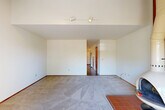 Located at 2802 Yulupa Ave in Santa Rosa, CA, this two-story home offers a practical and comfortable layout spread across two levels. The main floor provides the larger portion of the living space and features a carpeted living room illuminated by track lighting, with terracotta tile accents at the entry. Adjacent to the living room, the dining area connects seamlessly to the kitchen, which is outfitted with warm wood cabinetry, tile countertops, a tiled backsplash, white appliances including a dishwasher and range, and durable hardwood-style flooring. A peninsula with overhead cabinetry adds additional counter and storage space. The main floor also includes a den, providing flexible space for an office or additional living area. Upstairs, the private bedroom offers plush carpet flooring, a mirrored sliding closet, and a window with vertical blinds allowing natural light. Two bathrooms serve the home, one featuring a tub/shower combination with distinctive red mosaic tile surround and sliding glass doors. A dedicated laundry room and multiple closets add practical storage throughout. Outside, the property is framed by mature trees, lending a sense of privacy and natural character to the setting.