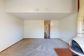 Located at 2802 Yulupa Ave in Santa Rosa, CA, this two-story home offers a practical and comfortable layout spread across two levels. The main floor provides the larger portion of the living space and features a carpeted living room illuminated by track lighting, with terracotta tile accents at the entry. Adjacent to the living room, the dining area connects seamlessly to the kitchen, which is outfitted with warm wood cabinetry, tile countertops, a tiled backsplash, white appliances including a dishwasher and range, and durable hardwood-style flooring. A peninsula with overhead cabinetry adds additional counter and storage space. The main floor also includes a den, providing flexible space for an office or additional living area. Upstairs, the private bedroom offers plush carpet flooring, a mirrored sliding closet, and a window with vertical blinds allowing natural light. Two bathrooms serve the home, one featuring a tub/shower combination with distinctive red mosaic tile surround and sliding glass doors. A dedicated laundry room and multiple closets add practical storage throughout. Outside, the property is framed by mature trees, lending a sense of privacy and natural character to the setting.