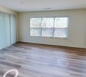 This 960 square foot apartment in Stamford, CT offers a thoughtful blend of comfort and functionality. The single-story layout maximizes space efficiency, featuring two bedrooms, including a generous 250 square foot primary bedroom. The heart of the home is an open-concept living area that seamlessly integrates the kitchen and living room, creating a spacious feel and facilitating easy entertaining.

The kitchen is a standout feature, boasting modern white cabinetry, stainless steel appliances, and a sleek black granite countertop. A pass-through window connects the kitchen to the living area, enhancing the open feel. Throughout the apartment, large windows allow ample natural light, brightening the neutral-toned walls and creating an airy atmosphere.

Flooring varies between rooms, with stylish wood-look laminate in the main living areas and plush carpeting in the bedrooms, offering both aesthetic appeal and comfort. The bedrooms are well-proportioned, with the second bedroom suitable for a guest room or home office. A closet provides additional storage space.

The apartment's design prioritizes functionality without sacrificing style, making it an ideal home for those seeking a modern, low-maintenance living space in a convenient Stamford location.