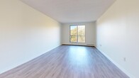Located at 746 Fanshawe Park Rd E in London, Ontario, this well-appointed 2-bedroom, 1-bathroom unit offers a clean, modern aesthetic throughout its thoughtfully laid-out single floor. Light-toned laminate flooring flows seamlessly across all living areas, creating a bright and cohesive feel.

The kitchen is efficiently designed with white shaker-style cabinetry, dark countertops, a classic white subway tile backsplash, stainless steel appliances including an over-the-range microwave and dishwasher, and a double-basin sink with a gooseneck faucet. The combined living and dining area provides generous open space, with access to a private balcony that overlooks a lush, tree-lined landscape — offering a peaceful, nature-filled outlook.

Both bedrooms are comfortably sized, each featuring windows with views of surrounding greenery, light-filled interiors, baseboard heating, and ample closet space with sliding doors. The primary bedroom is particularly spacious. The bathroom features a full soaker tub with a tiled surround in neutral tones of cream and taupe. A hallway with additional closets connects the rooms, and a dedicated entrance completes the functional layout of this well-maintained unit.