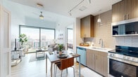 Located at 6919 Main St in Houston's vibrant Texas Medical Center corridor, this modern 2-bedroom, 2-bathroom residence offers a thoughtfully designed single-level layout with an efficient, open floor plan. Floor-to-ceiling windows flood the living and dining areas with abundant natural light while framing stunning panoramic views of the Houston skyline, surrounding greenspace, and city streets below. Light-toned wood flooring runs throughout, complementing the clean, contemporary aesthetic.

The open-concept kitchen and dining area is equipped with stainless steel appliances, warm wood cabinetry, tiled backsplash, and track lighting overhead. A compact dining space sits adjacent, ideal for everyday meals. The living room is anchored by expansive glass walls that maximize the sweeping urban vistas.

Both bedrooms feature large windows with city views, built-in closets, and direct access to their respective full bathrooms. Each bathroom is finished with wood-toned vanities, white subway tile surrounds, and tub-shower combinations. Additional storage is provided by dedicated closets near the entryway. A laundry area and ample cabinetry near the entry complete the practical layout of this well-appointed Houston residence.