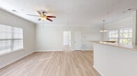 Located at 338 Walden Creek Way in Greenville, SC, this single-story, one-bedroom, one-bathroom home offers a well-designed layout with a clean, bright aesthetic throughout. Light wood-style flooring runs seamlessly across the main living areas, complemented by neutral walls and crisp white trim that create an airy, welcoming atmosphere.

The combined living and dining area is generously proportioned, featuring crown molding, a textured ceiling, and a ceiling fan with light fixture. Natural light filters in through large windows dressed with blinds, and a pendant chandelier anchors the dining space. The open-concept kitchen overlooks the living area via a breakfast bar with light stone-toned countertops, warm wood cabinetry, and black appliances, making it ideal for everyday living and entertaining.

The spacious primary bedroom offers a ceiling fan, a large window for natural light, and access to multiple closets, including generous walk-in storage. The full bathroom features a tub-shower combo with tile surround, a wood-toned vanity, and light wood flooring. Additional highlights include a dedicated laundry area, a private balcony, and five closets throughout. The home offers practical, comfortable living in a well-organized single-floor plan.