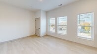 Located at 5400 School Ave in Hudsonville, MI, this thoughtfully designed one-bedroom, one-bathroom unit offers a clean, modern aesthetic across a single floor. Light wood flooring runs throughout the space, complementing bright white walls and trim that create a fresh, airy atmosphere. The open-concept layout seamlessly combines the living room, dining area, and kitchen into one cohesive space, maximizing functionality. The kitchen is equipped with stainless steel appliances, including a range and microwave, alongside warm wood cabinetry. A striking black-hardware sliding barn door serves as a stylish architectural accent connecting spaces. The bedroom is a comfortable, light-filled retreat featuring two windows with views to the outside and a louvered closet door for ventilation. Additional storage is provided by two closets, including one with sliding panel doors. The full bathroom is well-appointed with a single-sink vanity featuring wood cabinetry, a tub/shower combo, and coordinating light wood flooring. A dedicated laundry area and utility room add everyday convenience. The hallway connects all rooms efficiently, and the consistent use of white tones and natural light gives the entire unit a cohesive, welcoming ambiance.