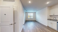 Located at 3225 W Colonial Dr in Orlando, FL, this one-bedroom unit offers a well-organized, single-floor layout designed to maximize every square foot of available space. The open-concept living area features durable hardwood-style flooring and neutral white walls, creating a bright and clean atmosphere. A window at the far end of the living space allows natural light to filter in, enhancing the airy feel of the room.

The kitchen is a standout feature, outfitted with crisp white shaker-style cabinetry, granite-look countertops, and a full suite of stainless steel appliances including a refrigerator, electric range, over-the-range microwave, and dishwasher. Light wood-toned flooring ties the kitchen seamlessly into the rest of the living area.

The bedroom is carpeted for comfort and includes a ceiling fan with light fixture, a window with blinds offering outside views, and direct access to a dedicated closet with built-in shelving. The room's neutral tones and soft carpeting provide a calm, restful environment.

Overall, the unit presents a clean, modern aesthetic with functional finishes throughout, making efficient use of its footprint. The consistent design language — neutral palettes, modern fixtures, and practical storage — gives the space a cohesive and move-in-ready appeal.