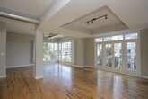 This single-floor urban loft blends industrial character with modern comfort in a thoughtfully designed open-concept layout. Warm, richly toned hardwood floors extend throughout the main living areas, complementing the soaring ceilings and exposed metallic ductwork that give the space its distinctive loft aesthetic. Large windows invite abundant natural light and frame views of the surrounding cityscape and greenery, creating a bright and airy atmosphere.

The expansive living area features a tray ceiling section with a ceiling fan, track lighting, and a striking tile-clad architectural column as a focal point. The kitchen is equipped with dark espresso cabinetry, granite countertops, stainless steel appliances, and a subway tile backsplash, offering both style and functionality. The space flows seamlessly between the kitchen and living zones, ideal for entertaining.

The bedrooms are well-proportioned with large windows offering tree and city views, continuing the hardwood flooring. The bathrooms are finished with slate-style tile floors, granite vanity countertops, white cabinetry, and over-toilet storage. The primary bathroom includes a walk-in closet with built-in shelving, adding a practical and organized storage solution. Throughout, the neutral warm-gray color palette ties all spaces together cohesively.
