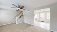 Located at 511 Avondale Rd in Dundalk, Maryland, this two-story home offers a well-organized layout spread across two floors. The main level features a carpeted living room with a ceiling fan, flowing into a separate dining area and a bright entry with hardwood-style flooring and a front-facing window. A staircase with white balustrades connects both levels. The kitchen is thoughtfully updated with crisp white shaker-style cabinetry, stone-look countertops, a stainless steel gas range with overhead ventilation, and light wood-style flooring — a clean, functional space for everyday cooking. A dedicated utility room and ample closet storage round out the practical features of the home. Upstairs, two carpeted bedrooms each include ceiling fans and windows that allow natural light to filter in. The spacious primary bedroom includes a closet and generous floor space. The second bedroom is cozy and equally well-lit. The shared full bathroom is neatly appointed with a white vanity, a tub-shower combination, and light wood-style tile flooring, maintaining the home's clean, neutral aesthetic throughout. With four closets total and a consistent light-toned palette, this home offers functional, comfortable living in a compact, efficient layout.