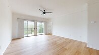Located at 104 E 28th Terrace in Kansas City, MO, this thoughtfully designed 2-bedroom, 2-bathroom home offers a clean, modern aesthetic throughout its single-floor layout. The spacious living room is anchored by light hardwood flooring, a sleek ceiling fan, and floor-to-ceiling sliding glass doors that open to a private balcony overlooking lush greenery and city skyline views, flooding the space with natural light. The kitchen is well-equipped with white shaker cabinetry, white quartz countertops, a subway tile backsplash, stainless steel appliances including a range and refrigerator, and a peninsula that adds additional prep and seating space. Both bedrooms feature plush carpeting, ceiling fans, and tray ceilings that lend an elevated sense of height. The generous primary bedroom includes direct access to a dedicated closet and a private en-suite bathroom, which is finished with warm hardwood floors, gray shaker vanity cabinetry, a white quartz countertop, matte black fixtures, and a separate tiled shower and tub area. The second bedroom benefits from an arched window view into an adjacent space, adding architectural charm. A dedicated laundry room with wire shelving and in-unit washer and dryer completes this well-appointed home.