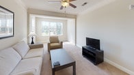 Located at 56 Bent Branch Loop Rd in Clayton, NC, this well-maintained single-floor home offers a thoughtfully designed layout with comfortable living spaces throughout. The living room is bright and welcoming, featuring plush carpeting, crown molding, a ceiling fan with light fixture, and a large bay-style window that allows abundant natural light to fill the room. The adjacent dining area flows seamlessly into the kitchen, which is equipped with rich dark wood cabinetry, granite countertops, hardwood-style flooring, black appliances including a top-freezer refrigerator and range, and track lighting overhead. The bedrooms are carpeted and generously sized, each featuring ceiling fans and large windows that frame views of the surrounding neighborhood and greenery. The bathroom includes a dark wood vanity with granite countertops and hardwood-style flooring, maintaining a cohesive design aesthetic throughout the home. A dedicated in-unit laundry room houses a full-sized washer and dryer with built-in shelving for additional storage. The spacious walk-in closet provides ample room for organization with wire shelving and hanging rods. Overall, this home combines practical functionality with a clean, neutral aesthetic ideal for comfortable everyday living.