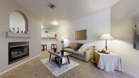 This single-floor residence offers a thoughtfully designed layout that balances comfort and functionality throughout. The living area is generously sized, featuring plush carpeting, neutral walls, and an abundance of natural light streaming through vertical blinds flanking a full-length entry door. The open-concept flow connects the living space seamlessly to the kitchen, which is outfitted with white cabinetry, granite-style countertops, a gas range, refrigerator, and a built-in microwave — all set atop warm wood-look flooring. A raised breakfast bar provides a casual dining option and further enhances the open feel between the kitchen and living area.

The bedrooms are carpeted and well-proportioned, offering a relaxed atmosphere. One bedroom features sliding glass door access to an outdoor area, while another includes a mirrored sliding closet with built-in shelving for organized storage. The bathroom is a standout space, showcasing a wide vanity with granite-style countertops, white cabinetry, a large mirror with overhead lighting, and wood-look flooring. A dedicated in-unit laundry area with side-by-side washer and dryer hookups adds everyday convenience. Overall, the residence presents a clean, practical, and inviting living environment.