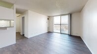 Located at 693 Urban Ct in Lakewood, Colorado, this one-bedroom, one-bathroom unit offers a well-organized single-level layout designed for comfortable everyday living. The open living and dining area is anchored by rich, dark hardwood-style flooring that runs throughout the home, complemented by clean white walls and a textured ceiling. A large sliding glass door floods the living space with natural light and provides direct access to a private balcony, offering elevated outdoor views of the surrounding Lakewood landscape.

The galley-style kitchen is efficiently arranged with white cabinetry extending to the ceiling, a double-basin sink, a full white appliance suite including a refrigerator, electric range, and dishwasher, and a built-in range hood overhead. The layout maximizes storage and functionality within a compact footprint.

The generously sized bedroom features its own sliding glass door to a secondary balcony, bringing in additional natural light and outdoor connectivity. A built-in closet with a full-length rod provides practical storage. The full bathroom is finished with white subway tile surrounding a tub/shower combination, stainless steel grab bars, and clean, simple fixtures. Throughout the unit, the bright, neutral palette and consistent flooring create a cohesive and inviting ambiance.
