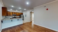 Located at 4000 S Dixieland Rd in Rogers, Arkansas, this single-story home offers a well-designed, open-concept layout that seamlessly connects the living and kitchen areas. Rich hardwood flooring flows throughout the main living spaces, complemented by crown molding and recessed lighting that create a clean, polished aesthetic. The living room is bright and inviting, featuring a ceiling fan and French doors that invite natural light from outside.

The kitchen is a standout feature, showcasing warm wood cabinetry extending to the ceiling, granite countertops, and a full suite of stainless steel appliances including a refrigerator, range, microwave, and dishwasher. A peninsula with bar seating adds functionality and visual appeal, while tile flooring grounds the space practically.

The bedrooms offer comfort with plush carpet, ceiling fans, and generous closet space, including dual closets in one room for enhanced storage. The bathrooms are finished with tile flooring, dark oil-rubbed bronze fixtures, and tub-shower combinations. One bathroom features a wood vanity with a granite countertop, maintaining design continuity with the kitchen. Neutral tones throughout the home create a cohesive, move-in-ready atmosphere suited for a variety of living styles.