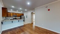 Located at 4000 S Dixieland Rd in Rogers, Arkansas, this single-story home offers a well-designed, open-concept layout that seamlessly connects the living and kitchen areas. Rich hardwood flooring flows throughout the main living spaces, complemented by crown molding and recessed lighting that create a clean, polished aesthetic. The living room is bright and inviting, featuring a ceiling fan and French doors that invite natural light from outside.

The kitchen is a standout feature, showcasing warm wood cabinetry extending to the ceiling, granite countertops, and a full suite of stainless steel appliances including a refrigerator, range, microwave, and dishwasher. A peninsula with bar seating adds functionality and visual appeal, while tile flooring grounds the space practically.

The bedrooms offer comfort with plush carpet, ceiling fans, and generous closet space, including dual closets in one room for enhanced storage. The bathrooms are finished with tile flooring, dark oil-rubbed bronze fixtures, and tub-shower combinations. One bathroom features a wood vanity with a granite countertop, maintaining design continuity with the kitchen. Neutral tones throughout the home create a cohesive, move-in-ready atmosphere suited for a variety of living styles.