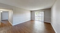 Located at 2320 S Conway Rd in Orlando, FL, this single-floor residence offers three bedrooms, two bathrooms, and a well-organized layout designed for comfortable everyday living. Wood-style flooring flows consistently throughout the home, complementing the neutral gray tones on the walls and clean white trim.

The open-concept living and dining area is generously proportioned, featuring a ceiling fan with integrated lighting, a textured ceiling, and a sliding glass door that opens to a private balcony, allowing natural light to fill the space. A pass-through window connects the living area to the kitchen, which is equipped with dark espresso cabinetry, granite countertops, a mosaic tile backsplash, and black appliances including a refrigerator and dishwasher.

The primary bedroom is a comfortable size with a dedicated closet and a window offering natural light. The additional bedrooms share similarly neutral finishes and wood-style flooring, making each room versatile. Both bathrooms feature granite-topped vanities, wood-style flooring, and full shower-tub combos with clean white tile surrounds and chrome fixtures. A closet provides additional dedicated storage. The overall ambiance is clean, functional, and move-in ready.