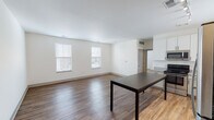 This single-floor unit in Huber Heights, Ohio offers a clean, modern design with a thoughtful layout and quality finishes throughout. The open-concept living and dining area is anchored by warm hardwood-style flooring and crisp white walls, creating a bright and welcoming atmosphere. Multiple windows fitted with blinds allow natural light to fill the space while maintaining privacy.

The kitchen is well-appointed with white upper cabinetry, two-tone lower cabinets, granite countertops, and a full suite of stainless steel appliances including a range, microwave, and dishwasher. Track lighting and pendant fixtures add both function and style, while a center island provides additional prep and dining space.

The bedrooms feature plush wall-to-wall carpeting and ample natural light from double windows. One bedroom includes an angled ceiling detail that adds architectural character to the room.

The bathroom is finished with wood-style flooring, a granite-topped vanity, and a glass-enclosed shower and tub combination. A narrow window above the shower area introduces natural light into the space.

Throughout the unit, neutral tones, clean lines, and consistent finishes contribute to a cohesive and move-in ready aesthetic suited for comfortable everyday living in the Huber Heights community.
