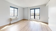 Located at 2615 E 29th St in Minneapolis, MN, this modern one-bedroom, one-bathroom unit offers a clean, contemporary design throughout. Light wood-tone plank flooring runs continuously across the entire floor plan, lending a cohesive and bright aesthetic to every room.

The open-concept kitchen and living area serves as the heart of the unit. The kitchen is outfitted with white shaker-style cabinetry, a gray tile backsplash, light quartz countertops, and a full suite of stainless steel appliances, including a range, over-the-range microwave, dishwasher, and refrigerator. The living area benefits from multiple large, black-framed windows that invite abundant natural light and offer elevated views of the surrounding Minneapolis neighborhood.

The bedroom is a well-proportioned, quiet retreat finished in crisp white walls and the same warm wood flooring. A sliding double-door closet provides practical storage. The bathroom features a full tub-shower combination with chrome fixtures and a clean white surround, accented by wood flooring that maintains the unit's consistent design language.

Throughout the space, the neutral white walls, modern hardware, and natural light create a fresh, minimalist ambiance well-suited for contemporary urban living.