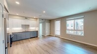 Located at North Grove in Riverside, CA, this 1-bedroom, 1-bathroom apartment offers 730 square feet of thoughtfully designed living space across a single floor. The modern kitchen is a standout feature, boasting two-tone shaker cabinetry in white and soft blue-gray, stainless steel appliances including a full-size refrigerator, gas range, over-the-range microwave, and dishwasher, complemented by a white subway tile backsplash and light hardwood flooring. The 120-square-foot bedroom features plush carpet, neutral sage-toned walls, and a large window that invites abundant natural light and views of the surrounding community. The full bathroom includes a shaker-style vanity with a dark countertop, large mirror, and a shower-tub combination, finished with wood-look flooring for a clean, cohesive aesthetic. A hallway connects the living spaces efficiently, while the private balcony offers elevated outdoor views of the contemporary multi-story residential complex and its landscaped corridors. The unit's overall design is clean and modern, with recessed lighting, neutral tones, and quality finishes throughout.