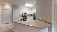 Located in Charlotte, NC, this single-floor residence on Dunbritton Lane offers a thoughtfully designed layout with a consistent neutral color palette and practical finishes throughout. The kitchen serves as a functional hub, featuring white shaker-style cabinetry, granite-look countertops, stainless steel appliances including a refrigerator, electric range, and built-in microwave, along with wood-look flooring and a peninsula with an integrated sink — ideal for both cooking and casual dining. Multiple bedrooms are finished with plush wall-to-wall carpeting, ceiling fans with lighting, and window blinds that allow for natural light. Several bedrooms include walk-in or reach-in closets for ample storage. One room stands out with elegant crown molding and a chair rail, adding a refined architectural detail. The bathrooms are finished with white tub-shower combinations, granite-topped vanities with white cabinetry, and wood-look flooring, offering a clean and cohesive aesthetic. The overall ambiance of the home is calm and move-in ready, with warm neutral tones, consistent trim work, and a well-organized floor plan that balances comfort and functionality throughout.